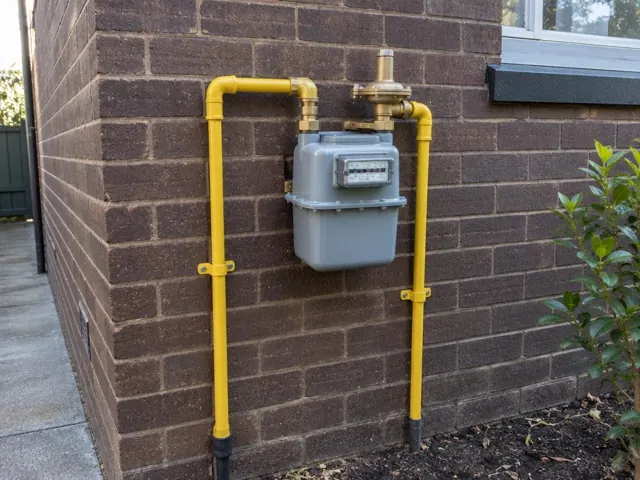 Exterior gas meter with new yellow pipework on a brick wall in Gordon